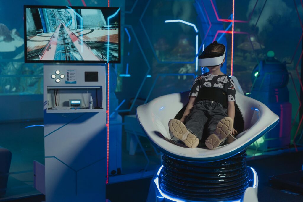 niño jugando en un juego de realidad virtual, con gafas de realidad virtual, una monitor y un asiento, decorado con luces neon blancas.