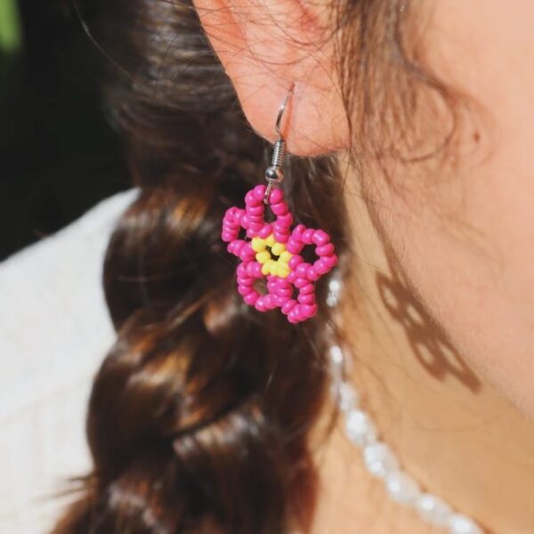 Pendientes veraniegos hechos de manera artesanal con delicadas cuentas en forma de flor en colores rosa fucsia y amarillos