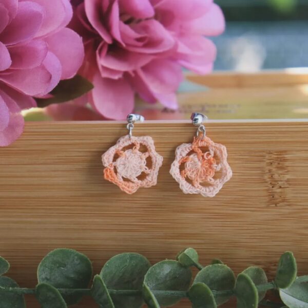 Pendientes artesanales realizados a ganchillo de forma circular con el pendiente en Plateado de color naranja degradado.