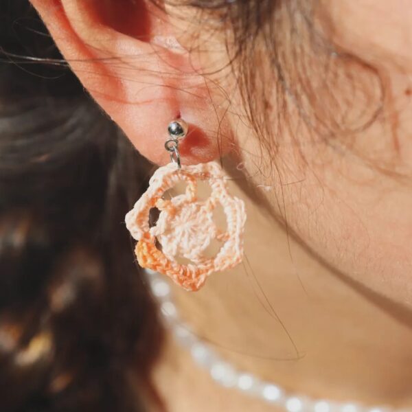 Pendientes artesanales realizados a ganchillo de forma circular con el pendiente en Plateado de color naranja degradado.