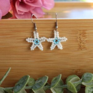 Pendientes veraniegos hechos de manera artesanal con delicadas cuentas en forma de estrella en colores azul celeste y blanco.
