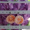 Pendientes artesanales realizados a ganchillo de forma circular con el pendiente en Plateado de color naranja degradado.