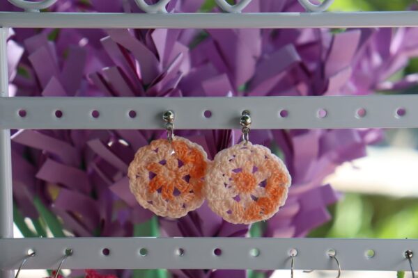 Pendientes artesanales realizados a ganchillo de forma circular con el pendiente en Plateado de color naranja degradado.