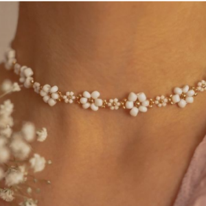 collar de cuentas blancas y doradas con pequeñas florecitas