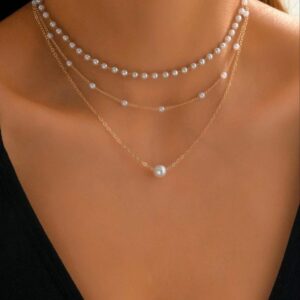 Collar de tres colgantes de perlas con la cadena en dorado.