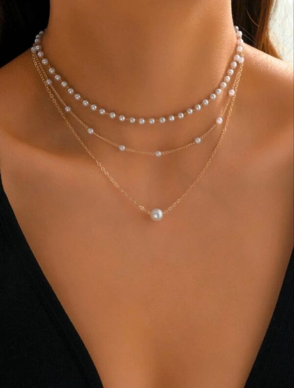 Collar de tres colgantes de perlas con la cadena en dorado.