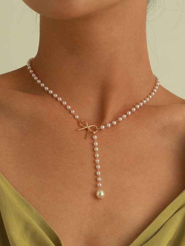Collar de perlas con un lazo dorado