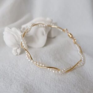 pulsera de perlas y una cinta dorada